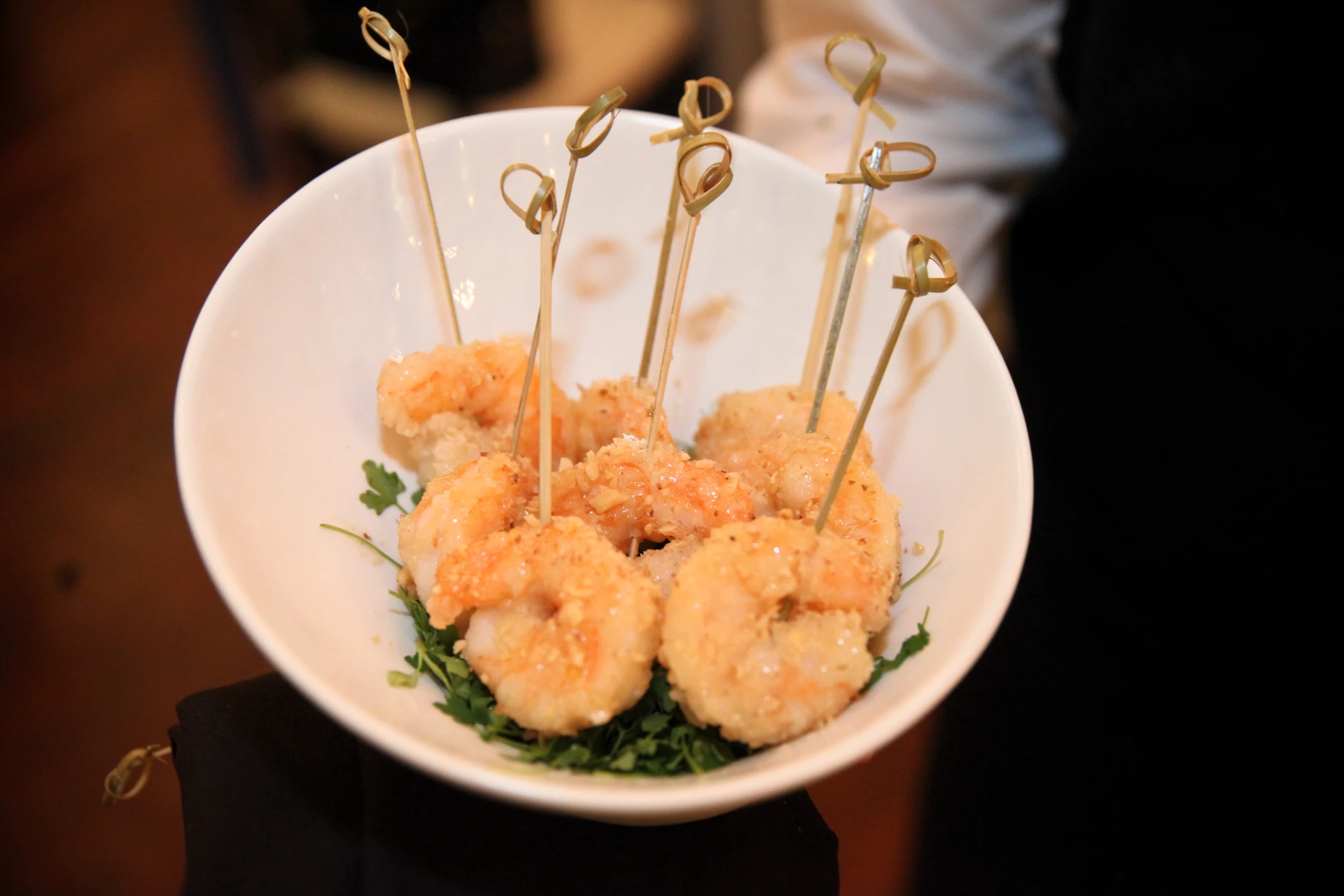 Garlic shrimp skewers served in a white bowl