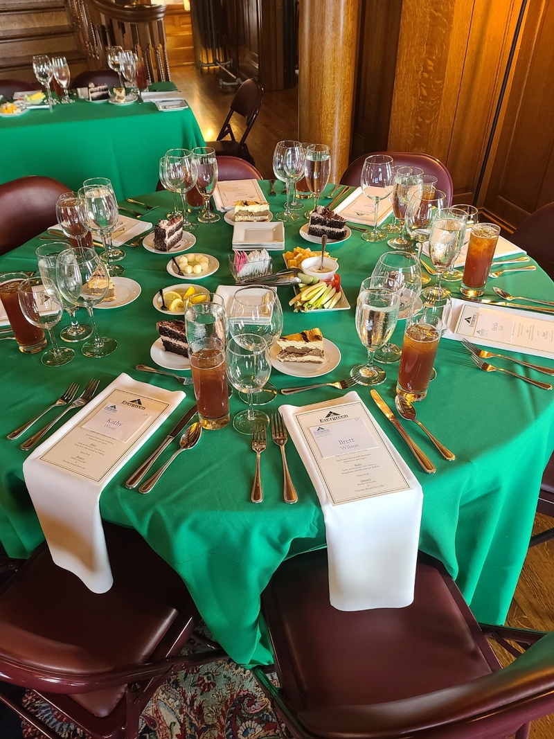 Banquet table set with printed menus, desserts and iced tea for a corporate luncheon