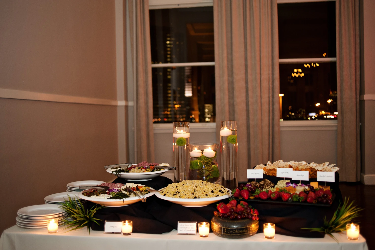 Candlelit antipasto and cheese display at an evening reception