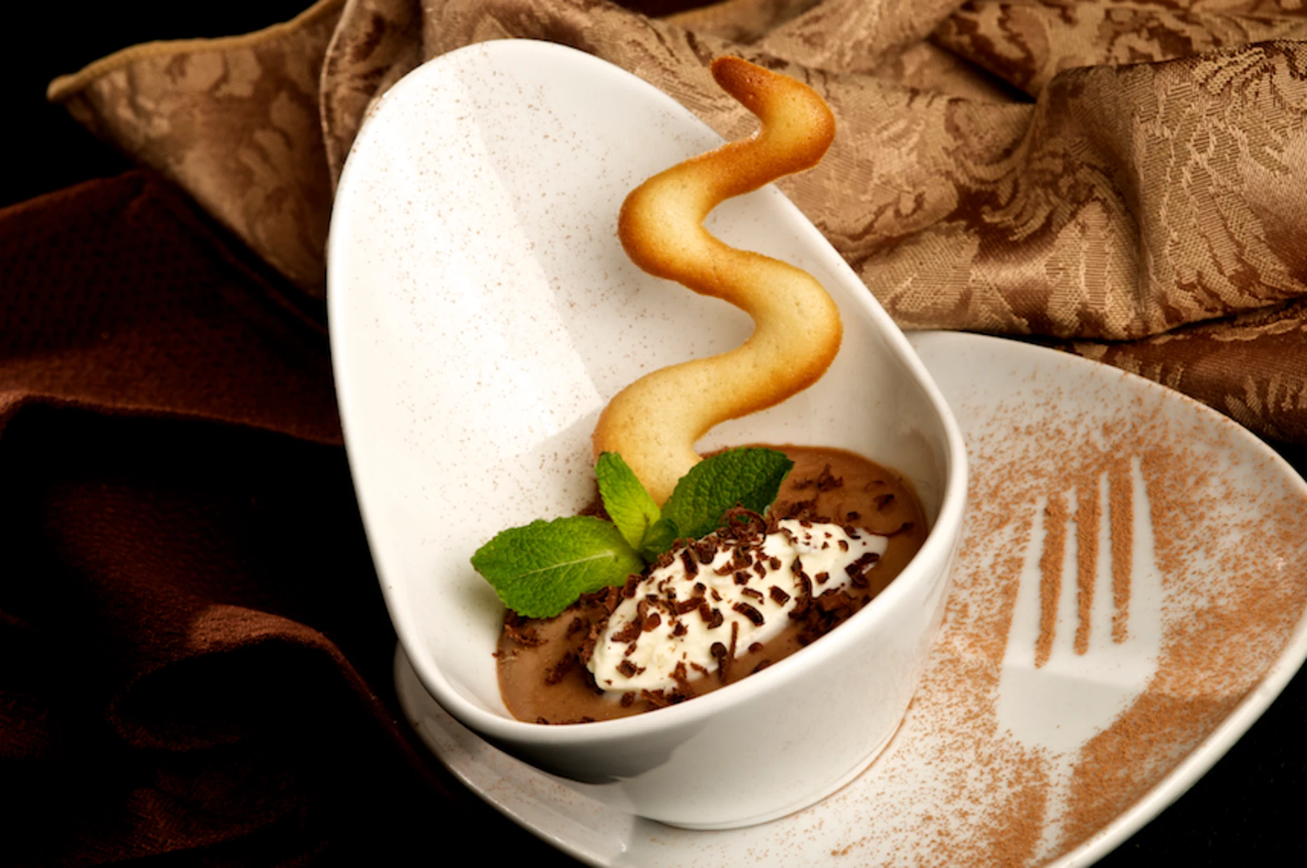 Chocolate mousse with whipped cream, mint and a tuile cookie