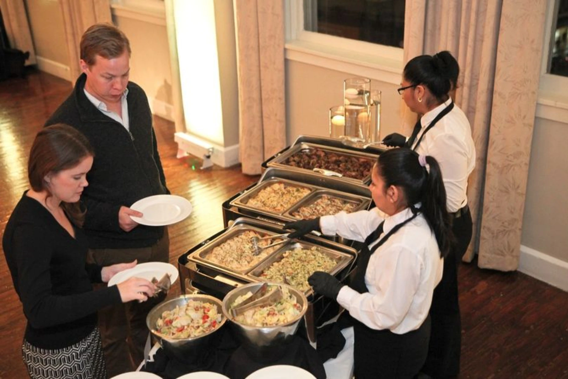 Servers plating a buffet line at a private event