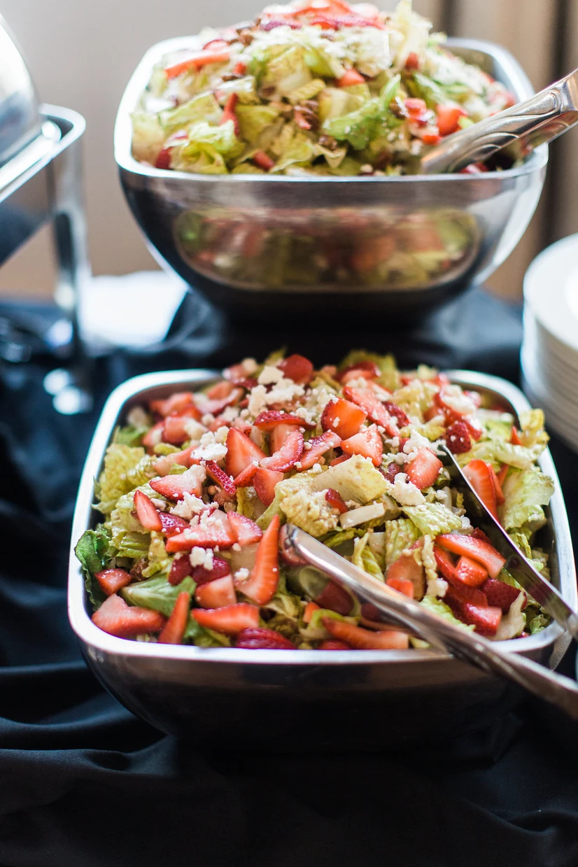 Strawberry romaine salad bowls with feta on a buffet line