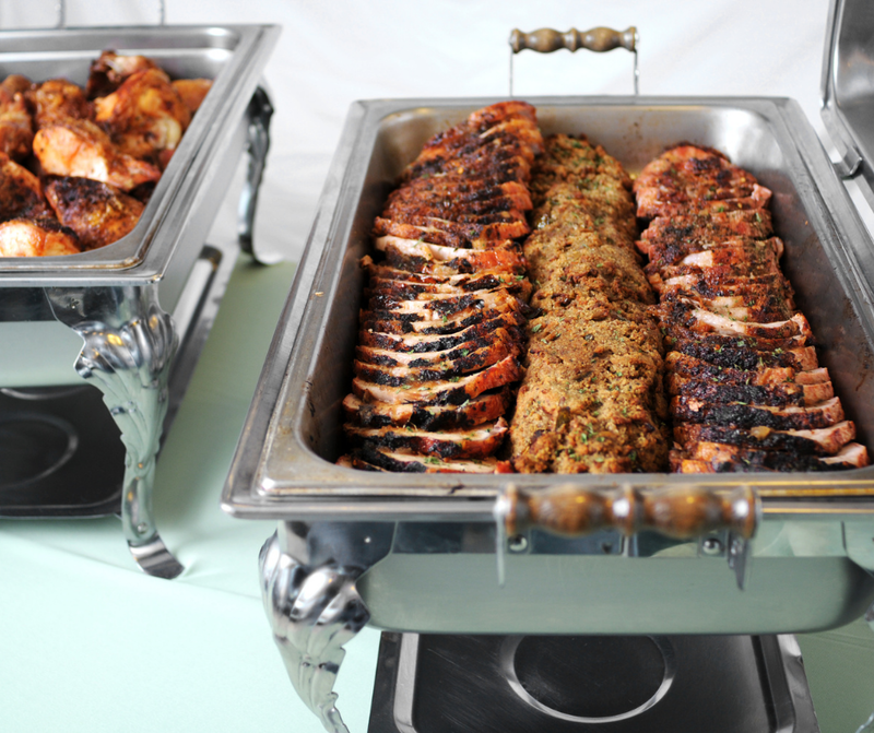 Carved roast pork and roasted potatoes in chafing dishes